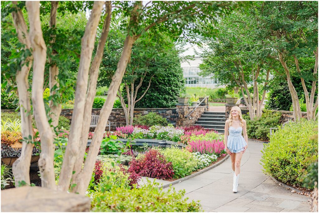 blue romper and white cowgirl boots at pond at Lewis Ginter Botanical Gardens for a summer senior session