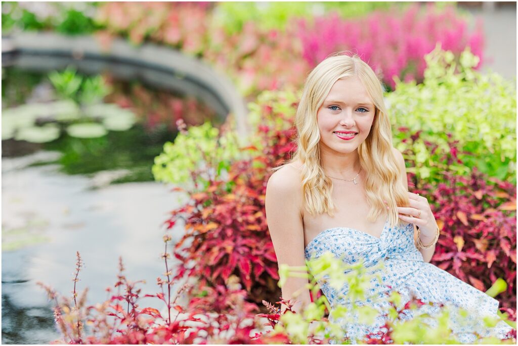 blue romper and white cowgirl boots at pond at Lewis Ginter Botanical Gardens for a summer senior session