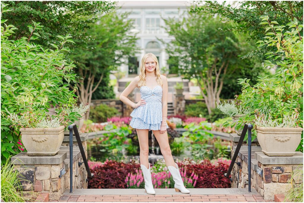 blue romper and white cowgirl boots at pond at Lewis Ginter Botanical Gardens for a summer senior session