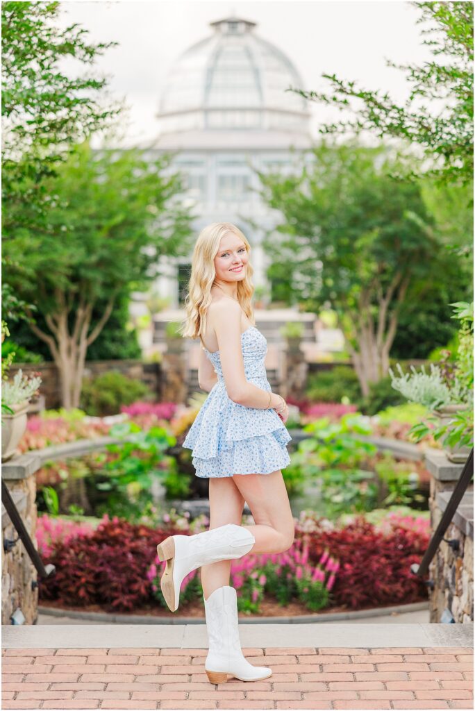 blue romper and white cowgirl boots at pond at Lewis Ginter Botanical Gardens for a summer senior session