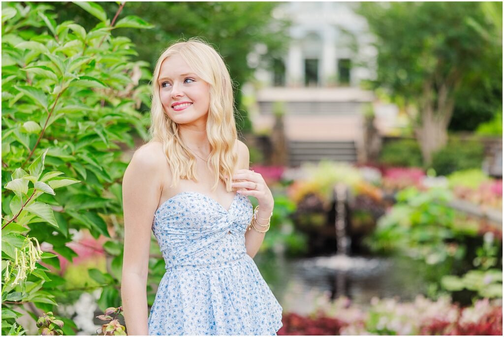 blue romper and white cowgirl boots at pond at Lewis Ginter Botanical Gardens for a summer senior session