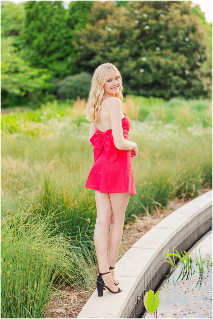 red dress with bow at the conservatory at Lewis Ginter Botanical Gardens for a summer senior session