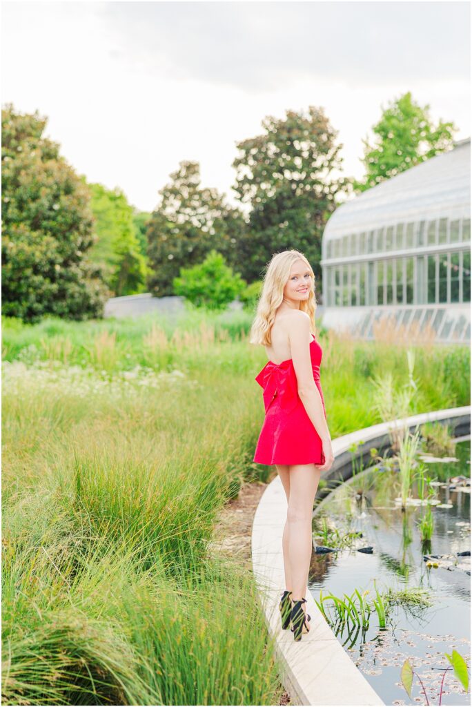 red dress with bow at the conservatory at Lewis Ginter Botanical Gardens for a summer senior session