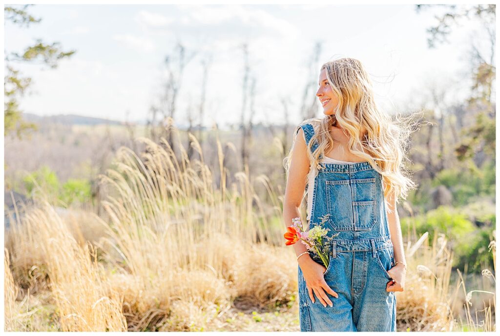 Asia's senior session at Swannanoa wearing overalls in the field